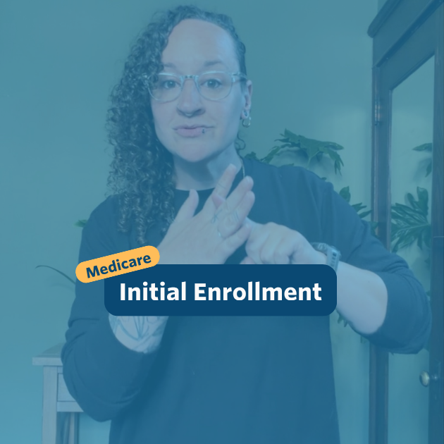 The post has a video thumbnail with blue shading overlaid. The top middle has "Medicare: Initial Enrollment&rdquo; in white text with light blue background, accompanied by a yellow bubble with &ldquo;Medicare&rdquo; in blue. In the video: A nonbinary person with long, curly brown hair shaved on the right side of their head stands in front of the camera. Behind them is a light wooden entry table with a potted monstera plant set against a green wall. They are wearing black pants and a black sweater with two gold chain necklaces.